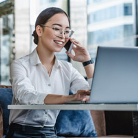 woman working on computer and talking on phone