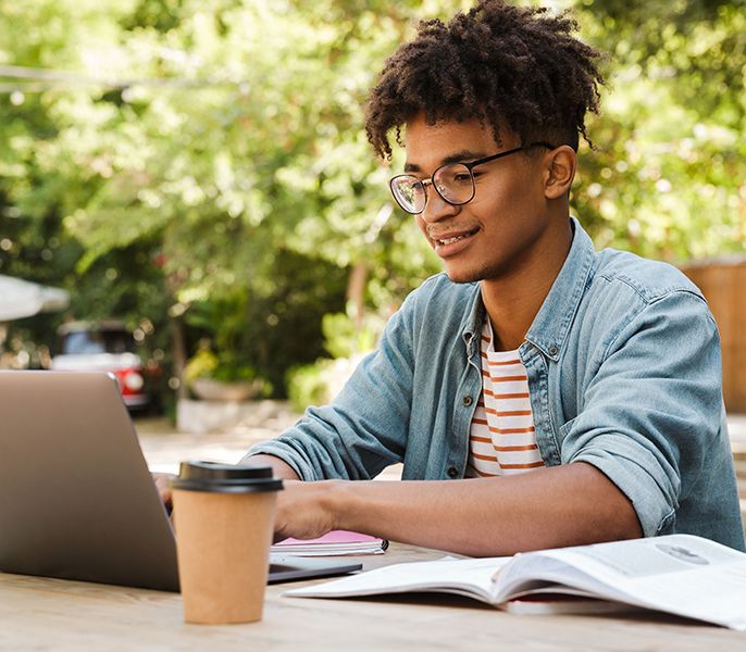 College student working on a laptop with cup of coffee