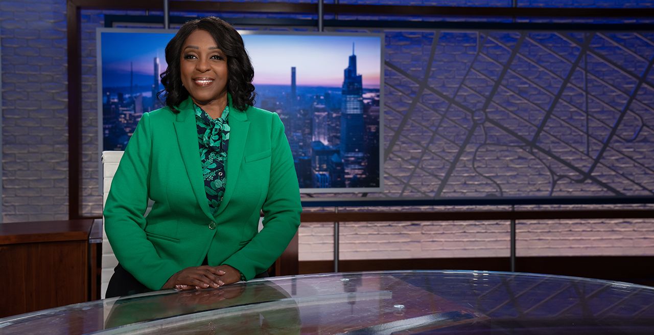 Spectrum News anchor Cheryl Wills sitting at the anchor desk in the studio